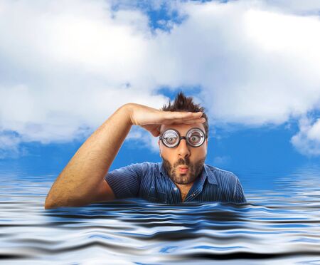 94726181-mann-mit-lustigen-ausdruck-und-starken-gläsern-die-weg-weg-im-wasser-des-meeres-schauen.jpg