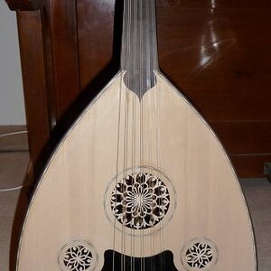 Oud

Das ist natürlich gar keine Gitarre. Vielleicht mit Ach und Krach der Vorläufer der Vorläufer dessen, was dann mal eine spanische Gitarre wurde.
Dieses Ding gabs billig auf eBay und ich war einfach neugierig. Qualitativ natürlich nichts edles. Aber der Klang ist ganz interessant. Die Orginal-"Mechaniken" sind nur gerade Wirbel, die im Holz sitzen. Da leider auch die Bohrungen nicht sonderlich exakt waren, haben die die Stimmung nicht gehalten. Ich hab sie durch Banjo-Mechaniken ersetzt.