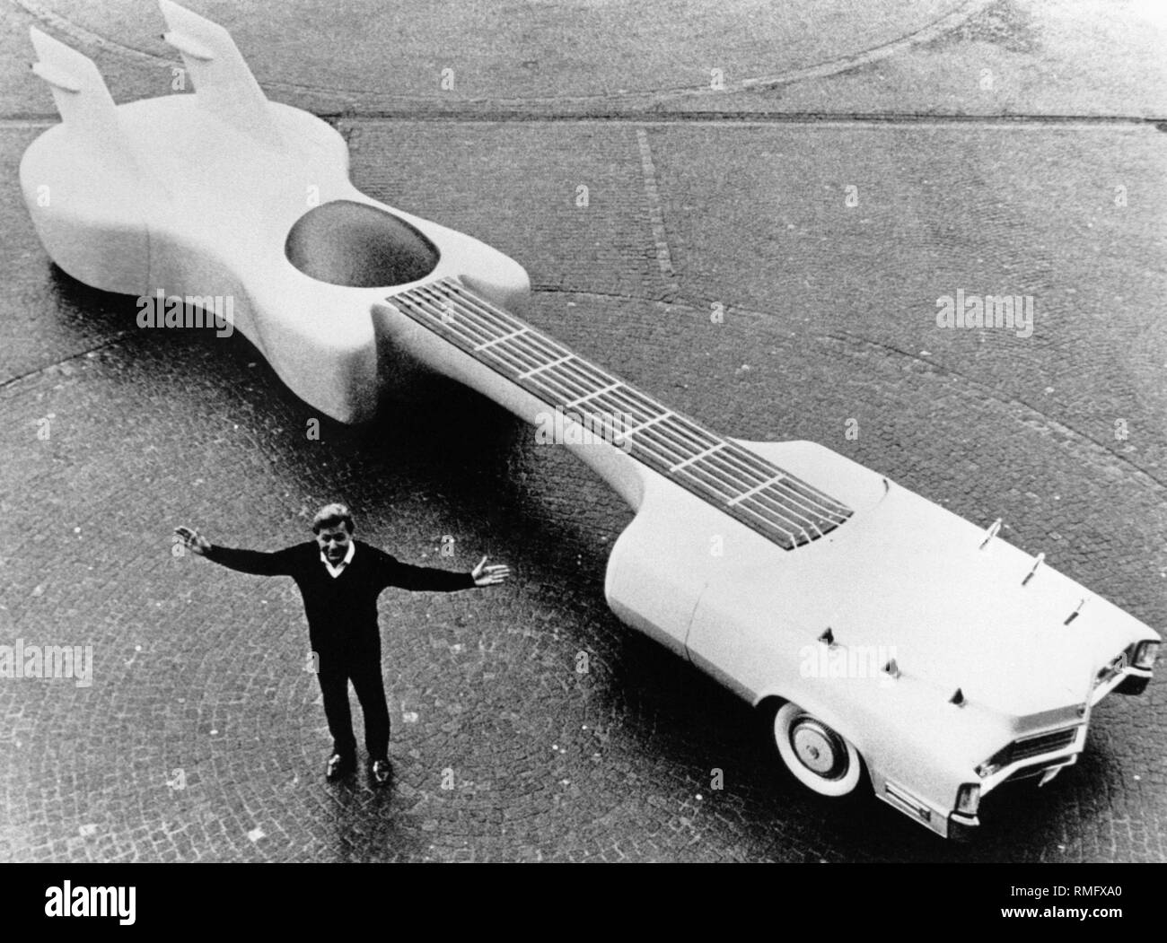 american-designer-jay-ohrberg-next-to-his-guitar-shaped-car-which-he-built-on-the-basis-of-a-cadillac-as-a-mobile-monument-in-honor-of-elvis-presley-the-vehicle-is-1219-meters-long-and-can-be-rented-for-5000-per-day-RMFXA0.jpg